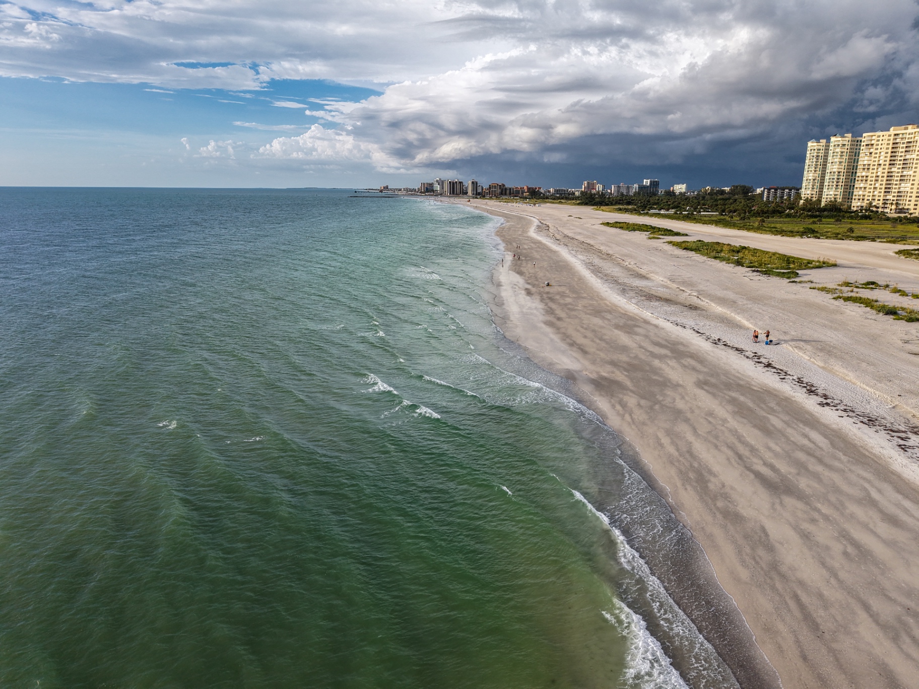 Aerial view of Clearwater Beach coastline with turquoise water and storm clouds