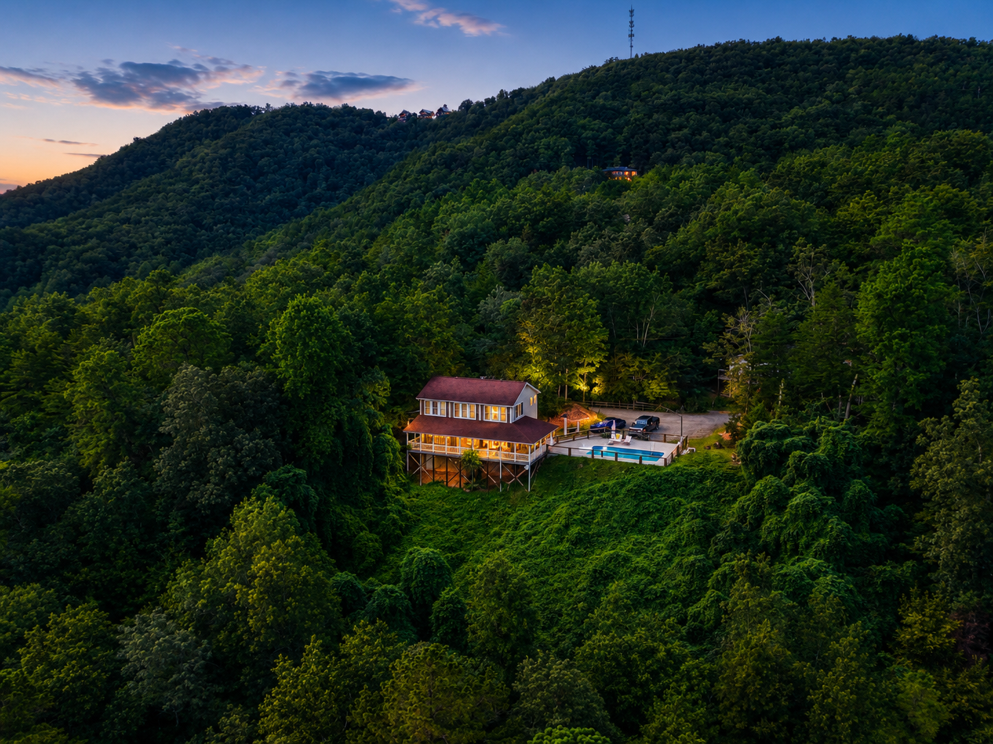 Mountain home at twilight surrounded by forest