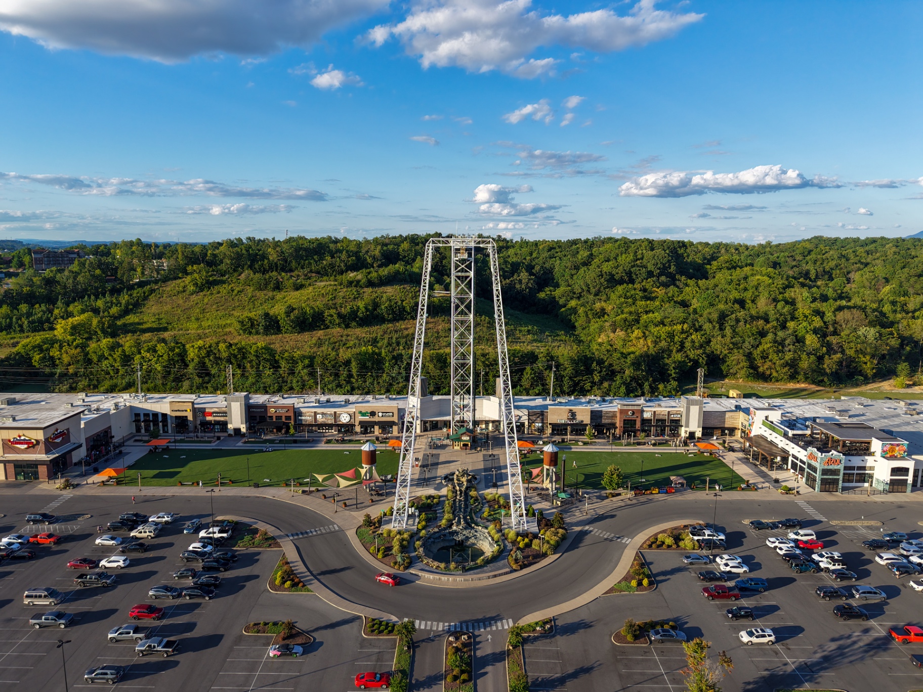 Aerial view of outdoor shopping plaza with observation tower and mountain backdrop
